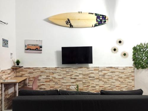 deskę surfingową wiszącą na ścianie salonu w obiekcie Apartamento Mar del norte, en Cotillo. w mieście Cotillo
