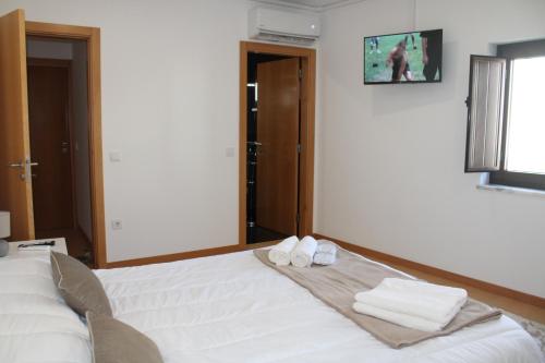 a bedroom with a bed with two towels on it at Miranda Village House in Miranda do Corvo