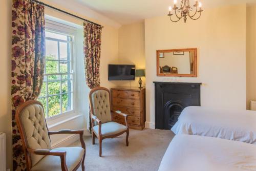 a bedroom with a bed and a tv and a fireplace at Beera Farmhouse in Milton Abbot