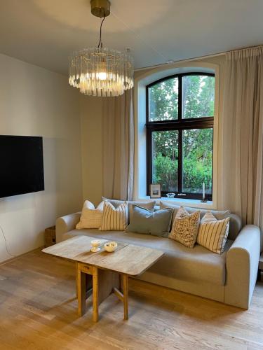 a living room with a couch and a table at Central apt near beach and city life in Kristiansand