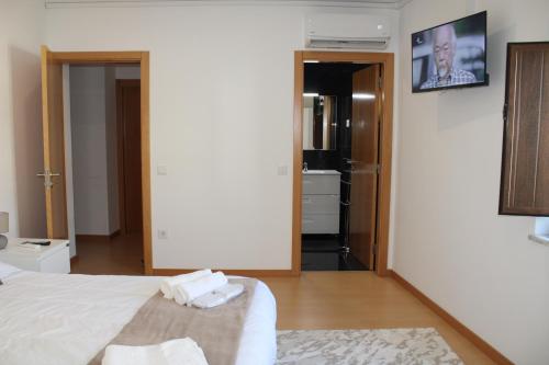 a bedroom with a bed with two towels on it at Miranda Village House in Miranda do Corvo