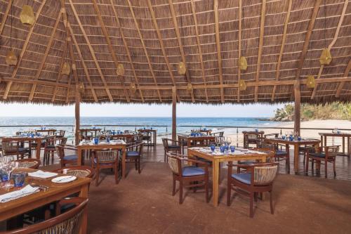 a restaurant with tables and chairs and a view of the ocean at Hyatt Ziva Puerto Vallarta - All Inclusive in Puerto Vallarta