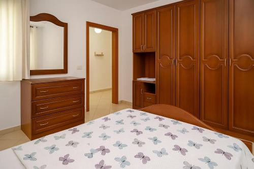 una camera da letto con un letto, una cassettiera e uno specchio di AURA apartaments29 a Durrës