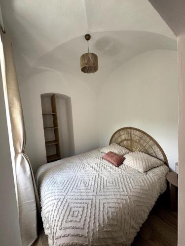 une chambre avec un lit avec une couette blanche dans l'établissement Charmant appartement, à Bastia
