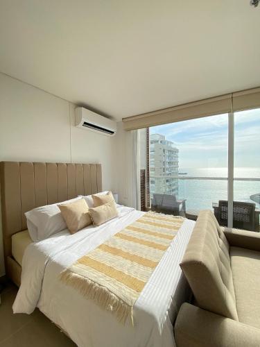a bedroom with a large bed and a large window at Eira: Luxury and Serenity by the Sea in Santa Marta in El Prado