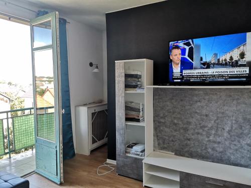 un salon avec une télévision à écran plat sur une étagère dans l'établissement Appartement Argenteuil avec Terrasse, à Argenteuil
