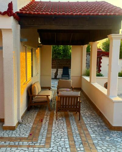 a porch of a house with chairs and a roof at Nereid Bungalow in Phanaes