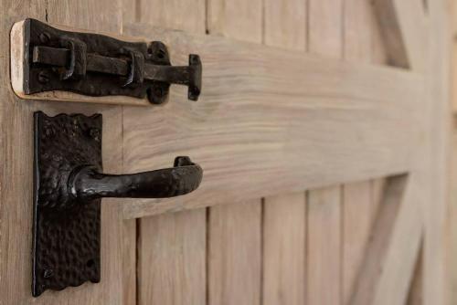 a black door handle on a wooden door at Willow Lodge In Hexton in Hexton