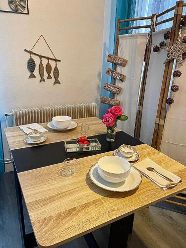 une table avec des assiettes et de la vaisselle en haut dans l'établissement Appart moderne REVE BLEU Hypercentre Blois à 5 min Château, à Blois