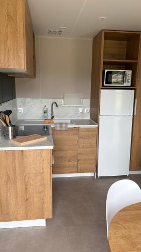 une cuisine avec un réfrigérateur blanc et un évier dans l'établissement Bungalow de charme près de Santa Giulia, à Porto-Vecchio