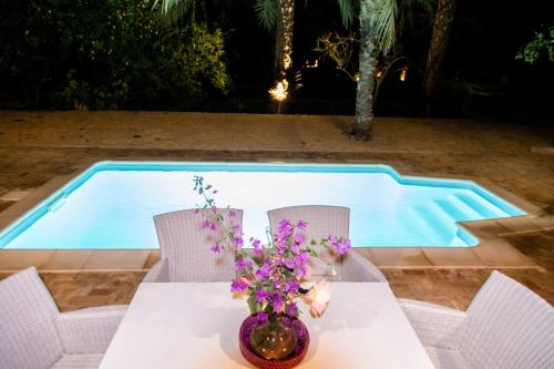 a table with flowers on it next to a pool at Dar Rouissi in Tozeur