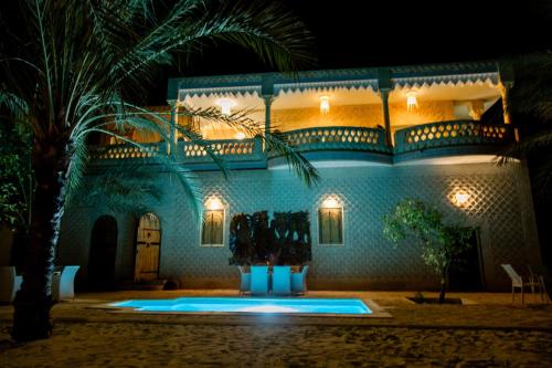 a villa with a swimming pool at night at Dar Rouissi in Tozeur