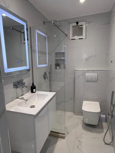 a white bathroom with a sink and a toilet at ELIO's Room in Durrës