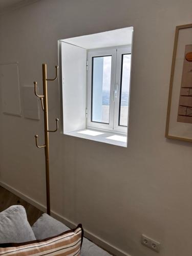 a mirror on a wall with a chair and a window at Casa do Aviador in Relva