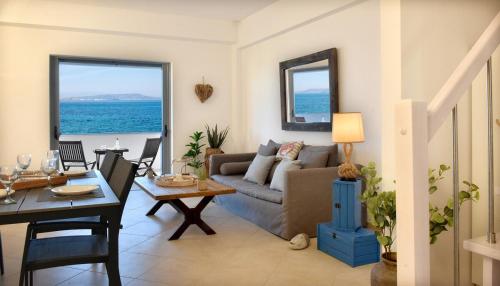 a living room with a couch and a table at Wave Whisper Home in Vathí
