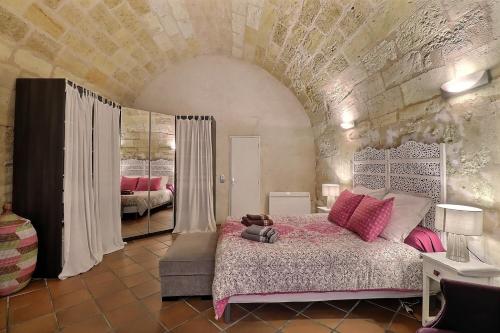 a bedroom with a large bed with pink pillows at appartement centre historique in Bordeaux