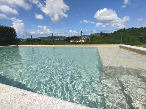 a swimming pool with clear blue water at Balutinha's house in Barcelos