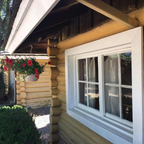 une fenêtre sur le côté d'une maison avec un pot de fleurs dans l'établissement Ashton Log Cabins, à Ashton