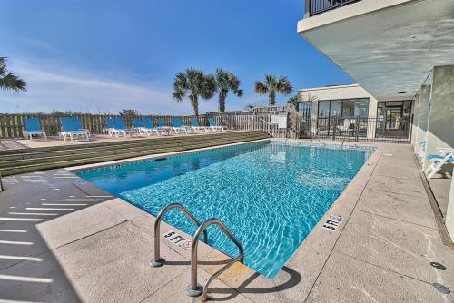 a swimming pool with blue chairs and a building at Oceanfront Waterpointe 1 Unit 803 3 bedroom 2 bath Balcony Pools in North Myrtle Beach