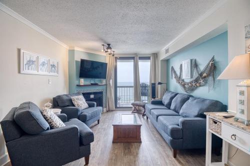 a living room with two blue couches and a fireplace at Oceanfront Waterpointe 1 Unit 803 3 bedroom 2 bath Balcony Pools in North Myrtle Beach