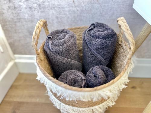 a basket filled with purple towels on a wooden floor at Suite Namaste - Cozy Apartment in Épinal