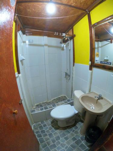 a small bathroom with a toilet and a sink at Hotel Relajate in Lobitos
