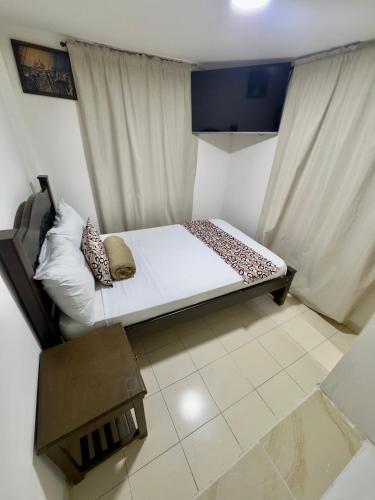 a small bedroom with a bed and a window at Hotel Tucan Pereira in Pereira