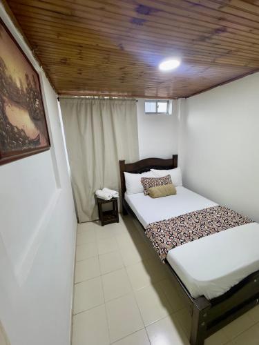 a bedroom with a bed with a wooden ceiling at Hotel Tucan Pereira in Pereira