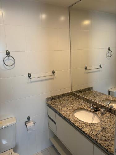 Apartamento Alto Padrão في غوارويا: حمام مزود بحوض ومِرآة