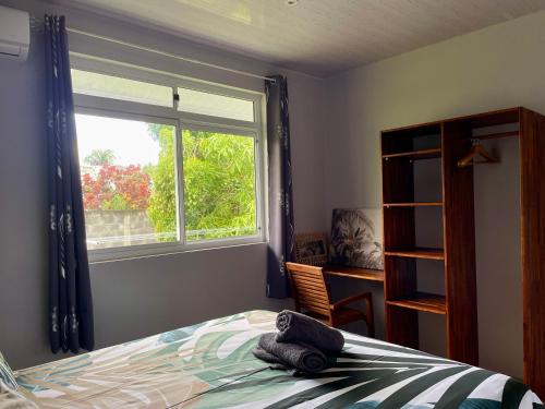 a bedroom with a bed and a window at Fare Raniarii in Tahu-Naoe