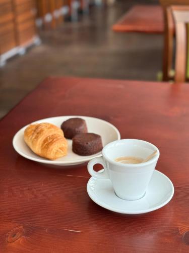 un piatto di dolci e una tazza di caffè su un tavolo di Hotel Paquito a Nova Gorica