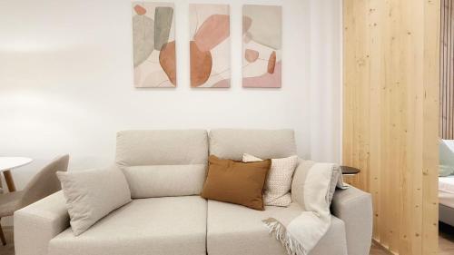 a living room with a couch and two paintings on the wall at AT Bilbaotown self check in in Bilbao
