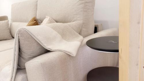 a white couch with a blanket on a table at AT Bilbaotown self check in in Bilbao