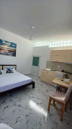 ein Schlafzimmer mit Bett und Schreibtisch sowie eine Küche in der Unterkunft Luani's Apartments in Vlorë