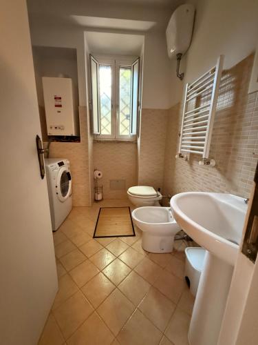 a bathroom with a sink and a toilet and a window at Casa Leone vicino al mare in Lido di Ostia