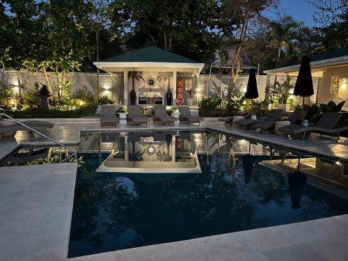a house with a swimming pool at night at The Providence Hotel Boutique in San Andrés