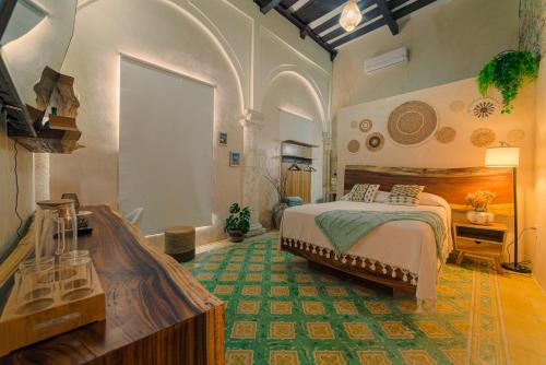 a bedroom with a bed and a desk in a room at Hotel Boutique Casa Lanz XVII in Campeche