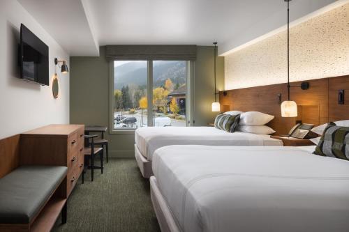 a hotel room with two beds and a window at Hotel Terra Jackson Hole, a Noble House Resort in Teton Village