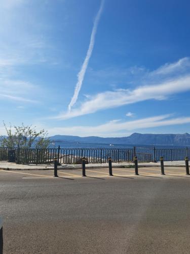 a fence on the side of a road next to the water at Deppy's Two-storey House in Corfu