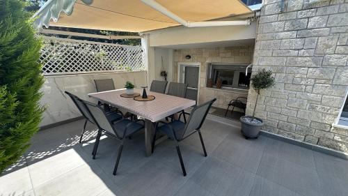 a table and chairs on a patio with an umbrella at Marko's Place in Hanioti