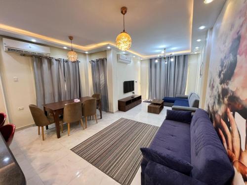 a living room with a couch and a dining room at ستيلا هايتس الساحل الشمالي in Sīdī ‘Abd ar Raḩmān