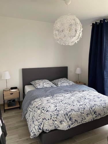 une chambre avec un lit et un lustre dans l'établissement Maison familiale en bord de mer avec JACUZZI, à Vaux-sur-Mer
