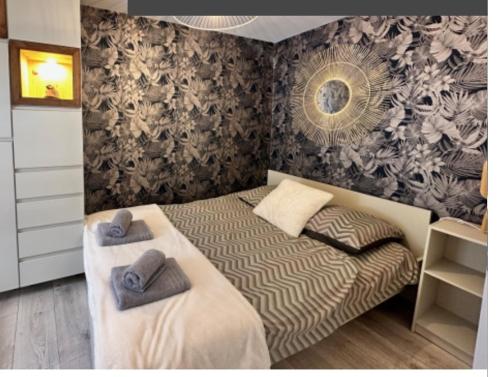 une chambre avec deux lits avec des serviettes dessus dans l'établissement Adonis, à Paimpol