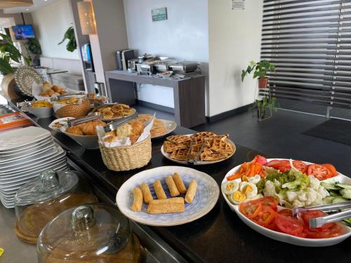 a buffet with plates of food on a counter at Hotel bh El Poblado in Medellín