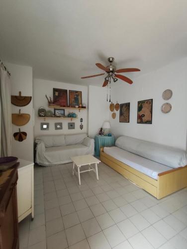 a living room with two beds and a ceiling fan at CASA CELESTE in San Nicola Arcella