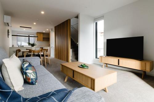 a living room with a couch and a tv at Luxe 3BR, 2Bath Townhouse w Private Garage in CBD in Wellington