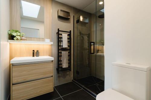 a bathroom with a shower and a sink and a toilet at Luxe 3BR, 2Bath Townhouse w Private Garage in CBD in Wellington
