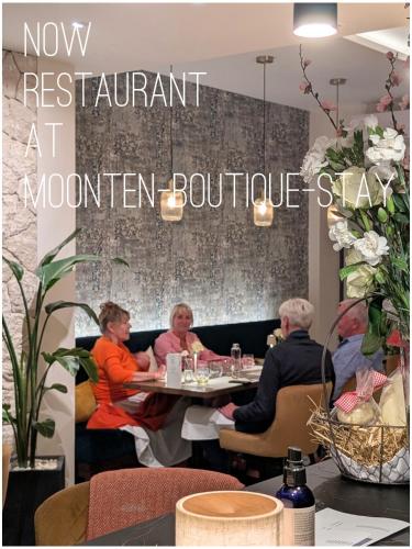 a group of people sitting at a table in a restaurant at MOONTEN Boutique Stay in Sóller