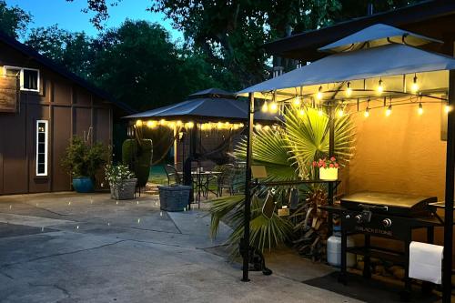 a patio with an umbrella and a table and chairs at Modern Entertainment Getaway Off Sacramento River! in Anderson