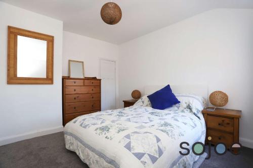 une chambre avec un lit, une commode et un miroir dans l'établissement Seaside cottage close to beach, à Pakefield